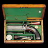 A Cased 31-Bore Irish Over-And-Under Single-Trigger Percussion Pistol By Trulock & Son, 9 Dawson St., Dublin, circa 1840, With etched twist octagonal rifled barrels, the top one sighted and engraved with the address within a shaped panel, scroll engraved case-hardened breech block, signed scroll engraved case-hardened back-action locks each with blued safety-catch (right hammer a working replacement), chequered figured walnut butt, blued scroll engraved iron trigger-guard, silver escutcheon, blued scroll engraved pommel, and some original finish: in lined and fitted oak case with accessories including Sykes flask (spring defective), 9in. (22.9cm.)